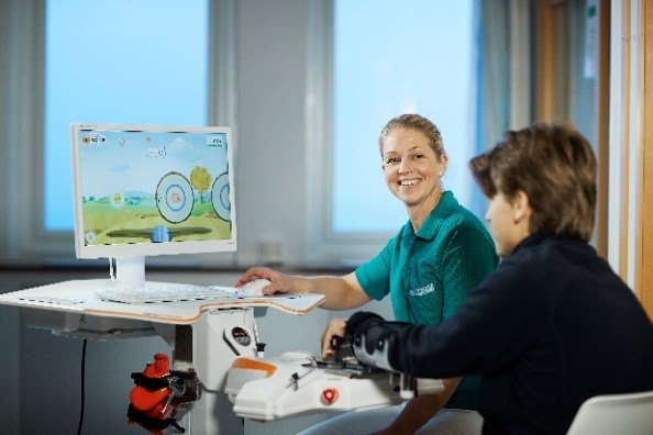Figur 1. Pasient får opplæring robottrening, i robotlab ved Sunnaas sykehus.jpg